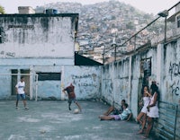 a group of people playing soccer in a slum in rio de janeiro, brazil